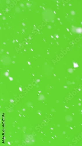 Vertical video of snow snowing on green screen background
