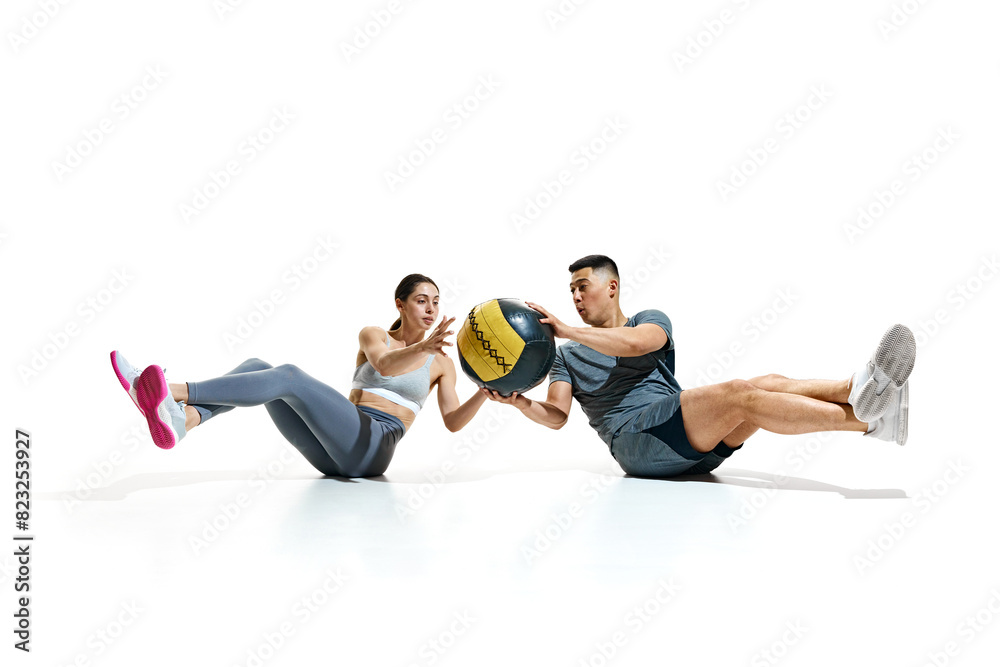 Athletic man and woman working out together with medicine ball against white studio background. Workout. Concept of people in sport, healthy lifestyle, teamwork, motivation. Ad Athletic man and woman working out together with medicine ball against white studio background. Workout. Concept of people in sport, healthy lifestyle, teamwork, motivation. Ad