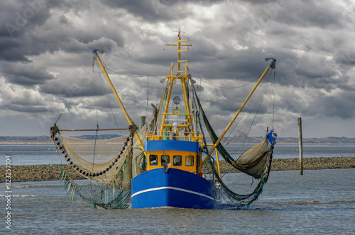 returning shrimp boat into the harbor of Neuharlingersiel,North Sea,East Frisia,lower saxony,Germany