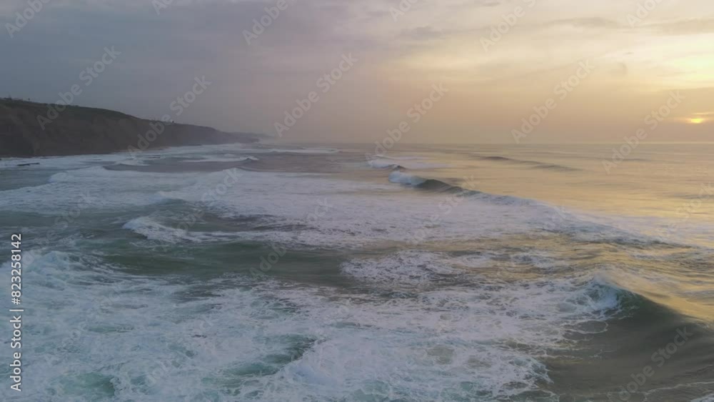 Waves of Atlantic Ocean crashing at sunset in Magoito Beach, Portugal. Aerial shot.