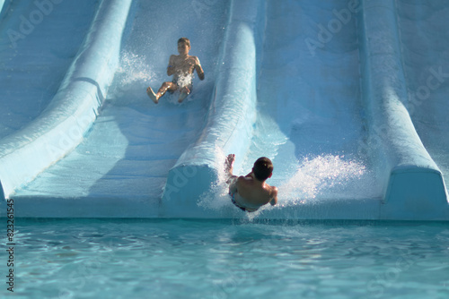 Man Riding Water Slide in Pool, Exciting Aquatic Adventure for Thrill Seekers photo