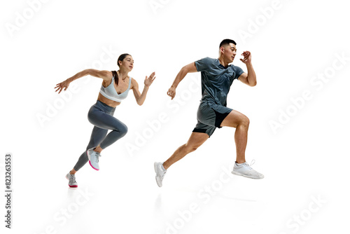 Side view dynamic photo of woman and man in mid-run, demonstrating their athletic prowess against white studio background. Concept of people in sport, healthy lifestyle, teamwork, motivation. Ad