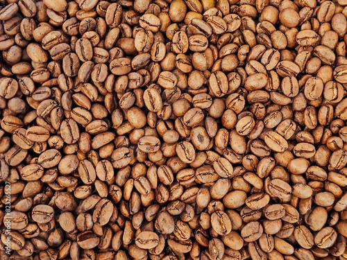Real brown whole bean coffee texture pattern background come form organic farm and already roast for cafe coffee shop use