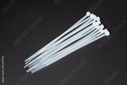 Plastic self-locking nylon cable ties on black background