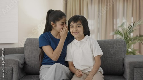 Indian sister telling a secret to her brother