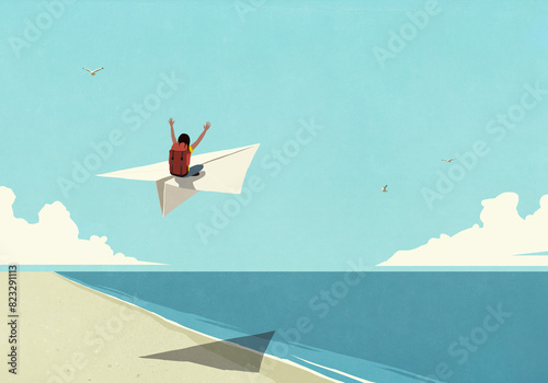 Carefree woman with backpack enjoying travel, riding paper airplane over sunny ocean beach
 photo