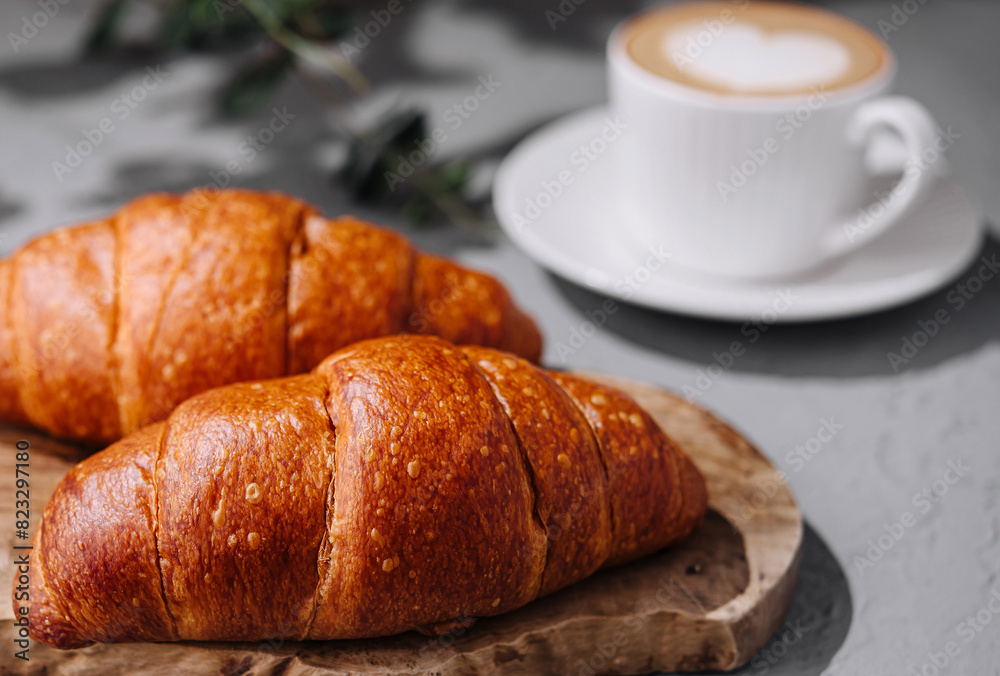 Fresh croissants and coffee on table