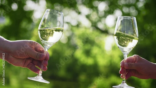 Couple with glasses of white wine outdoors, closeup