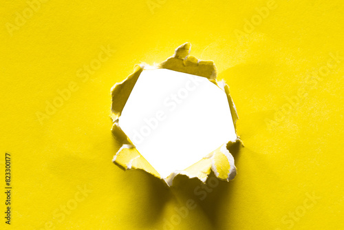 torn hole of yellow paper photo