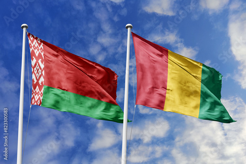 3d illustration. Belarus and Guinea Flag waving in sky. High detailed waving flag. 3D render. Waving in sky. Flags fluttered in the cloudy sky.