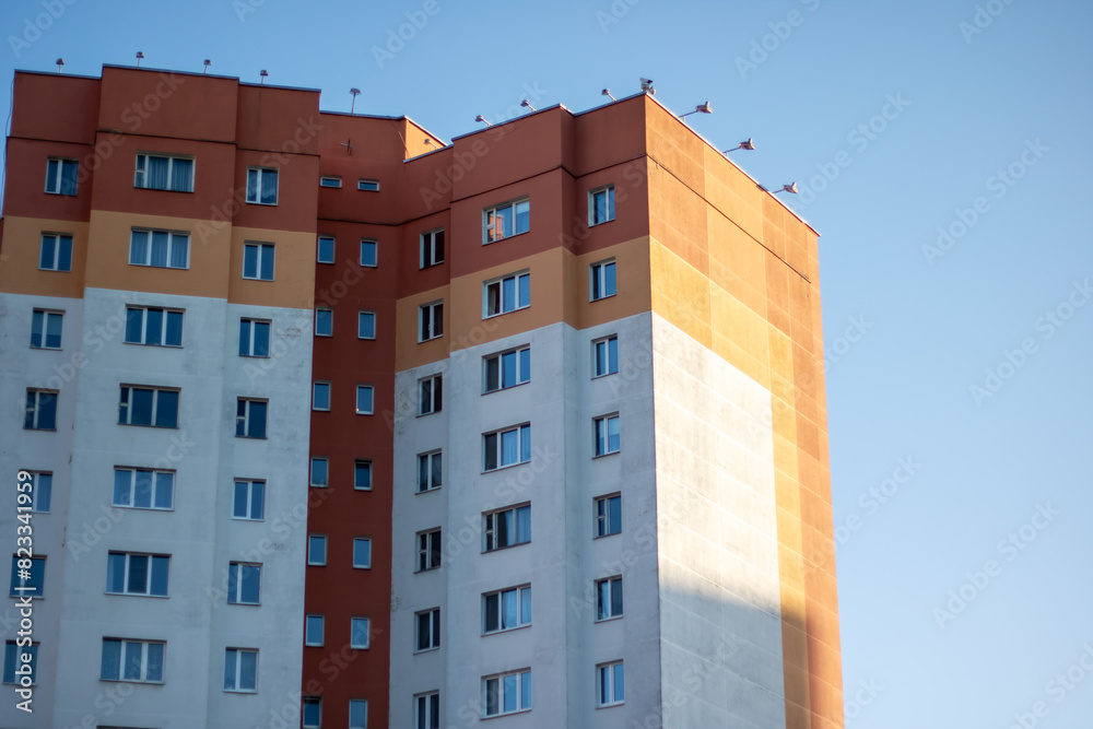 A tall tower block against a backdrop of azure sky in an urban setting