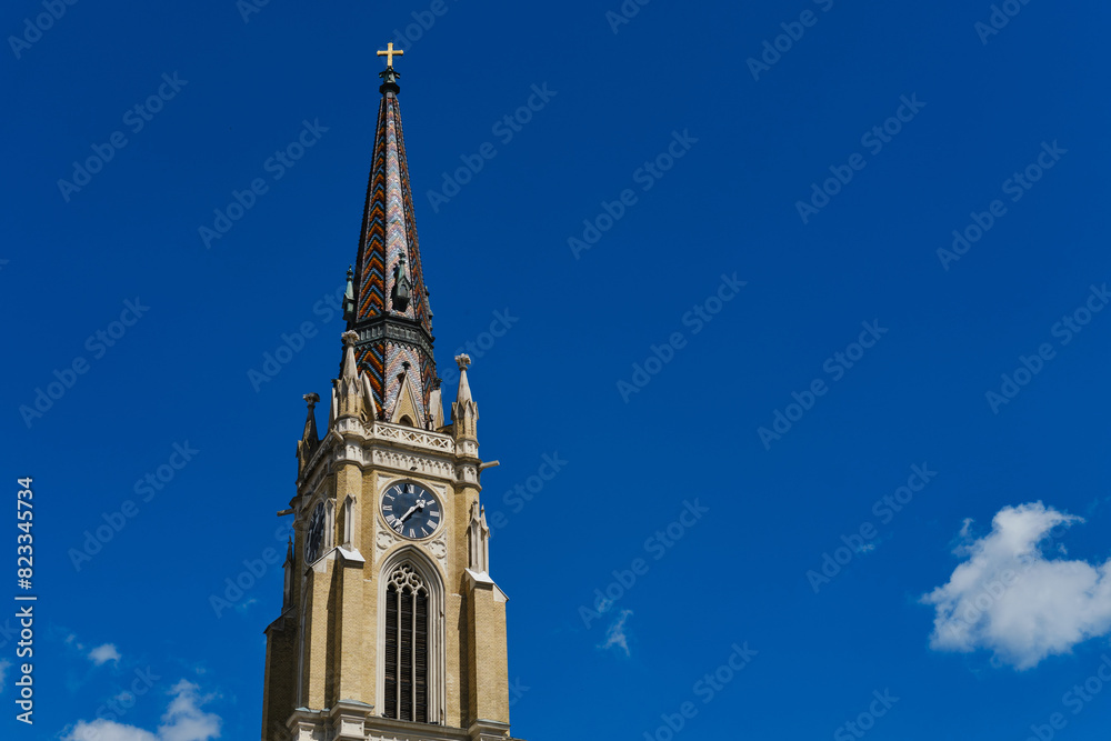 Name of Mary Church, also known as Novi Sad catholic cathedral or crkva imena marijinog during a sunny day. The cathedral is one of the most important landmarks. Tower with clock close view. Name of Mary Church, also known as Novi Sad catholic cathedral or crkva imena marijinog during a sunny day. The cathedral is one of the most important landmarks. Tower with clock close view.