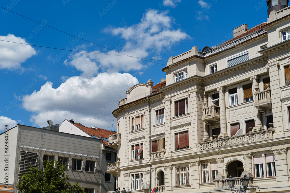 Neoclassic architecture, white building in Novi sad, Serbia. The facade of an old renovated building with columns on a sunny spring day. Neoclassic architecture, white building in Novi sad, Serbia. The facade of an old renovated building with columns on a sunny spring day.