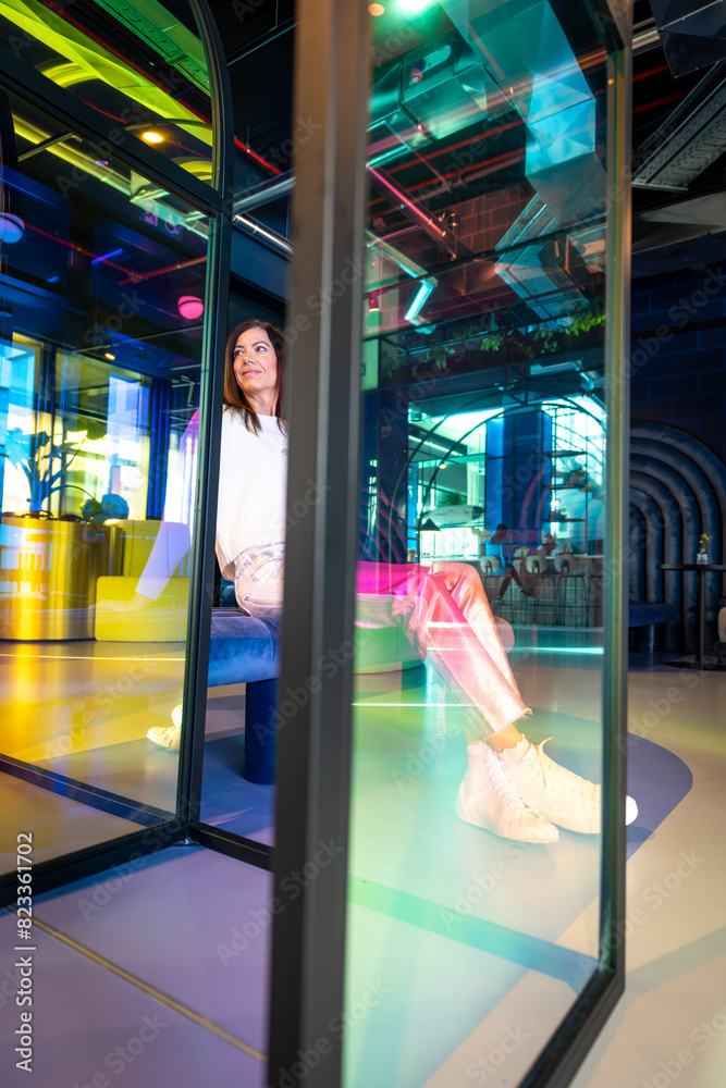 Fototapeta premium there is a woman sitting inside of a glass case looking into the camera