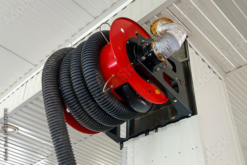 Exhaust gas removal system from running vehicle in a car service center. Drum with exhaust hose