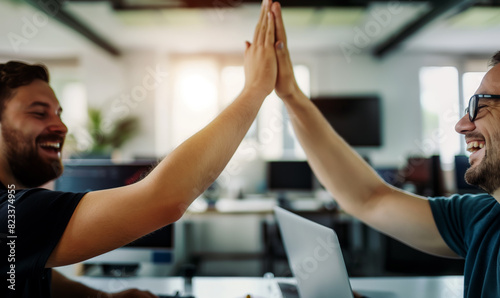 Happy male colleagues doing high-five in corporate office