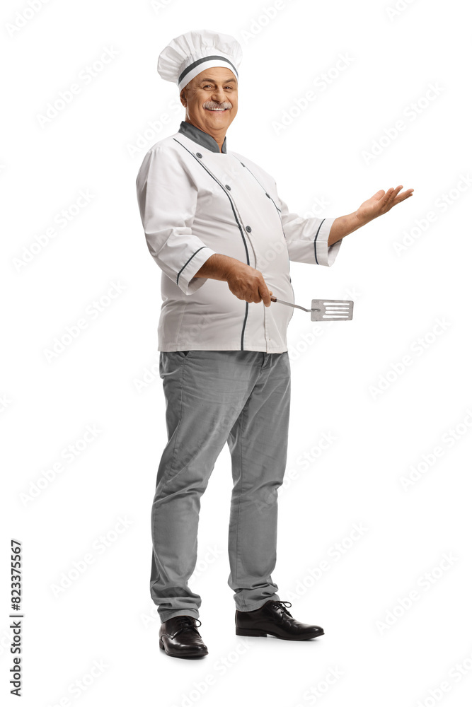 Mature male chef holding a turner utensil Mature male chef holding a turner utensil