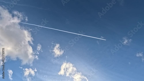 Timelapse of white clouds and chemtrails in the blue sky on a sunny day