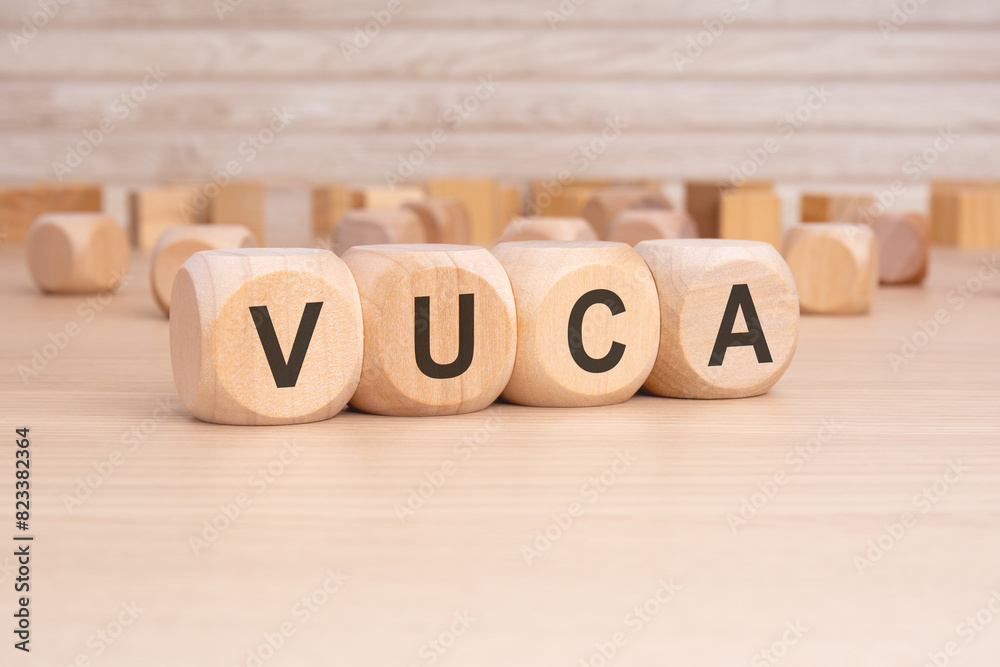 short word english text VUCA on a wooden cubes with wooden background short word english text VUCA on a wooden cubes with wooden background