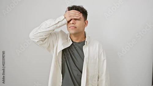 Oops! clueless young arab man in casual clothes smacks head in forgetful regret. amid stress, he realizes his foolish mistake - bad memory! isolated on a crisp white background.