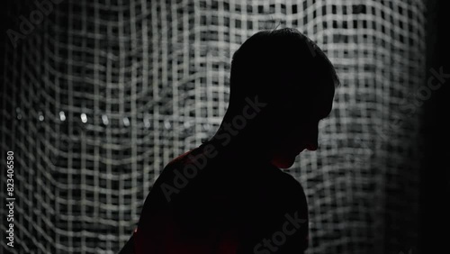 Dark Silhouette Of Sportsman After Workout, Athletic Man Breathing Hard And Resting In Stadium photo