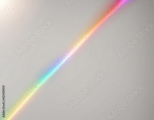 A texture overlay effect of blurred rainbow light refraction for photos and mockups. Organic diagonal holographic flare on a white wall. Realistic natural light effects.
