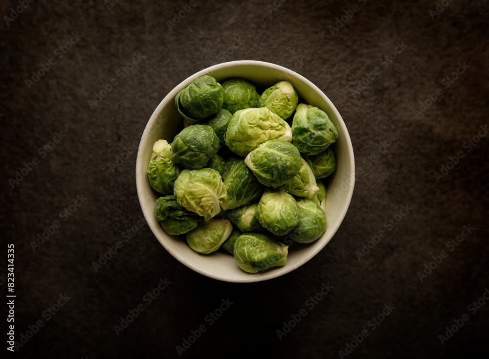 Top view of brussels sprouts in a white bowl on a wooden table Top view of brussels sprouts in a white bowl on a wooden table