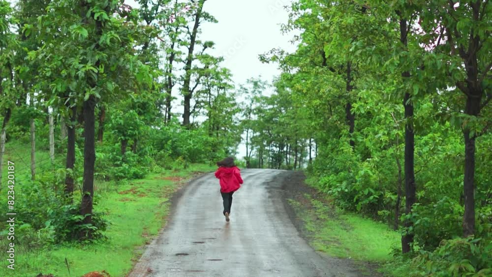 Happy Indian teenager girl running on the road covered with green trees on both side during monsoon season at Saputara, Gujarat, India. Girl running in forest during holidays. Rainy days in Sahyadri Happy Indian teenager girl running on the road covered with green trees on both side during monsoon season at Saputara, Gujarat, India. Girl running in forest during holidays. Rainy days in Sahyadri