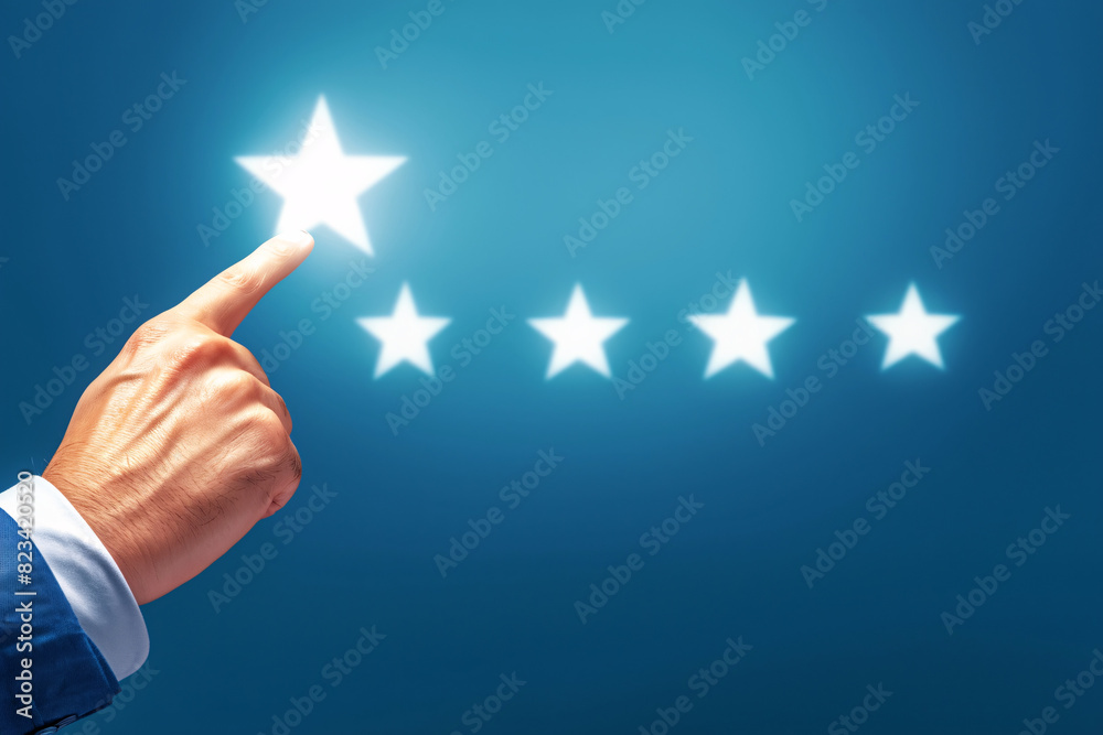 Hand pointing at the first star in a five-star rating on a blue background Hand pointing at the first star in a five-star rating on a blue background