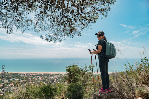 Happy hiker in the mountains and the Mediterranean coast in the background.