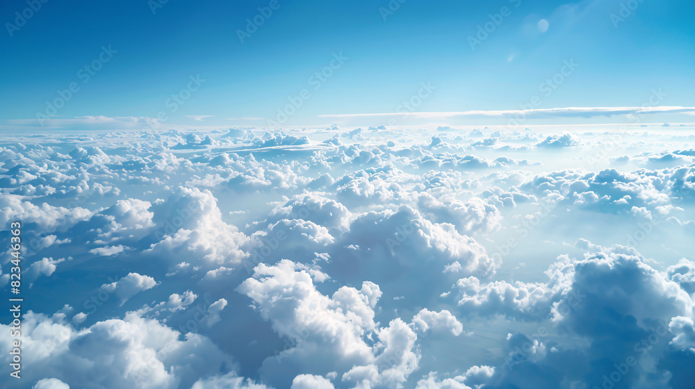 Fototapeta premium Aerial view of fluffy white clouds and blue sky. Download this stunning aerial photograph of a breathtaking cloudscape, featuring fluffy white clouds against a vibrant blue sky.