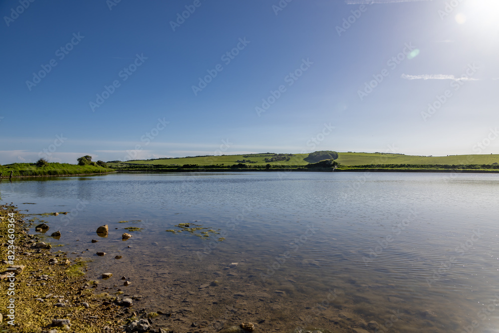 A view over the Cuckmere River in the South Downs, with a blue sky overhead