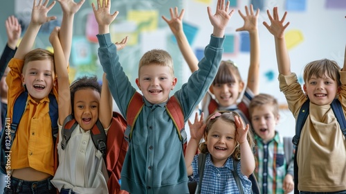 Childhood and school. Portrait of funny group of classmates from elementary school having fun in classroom. Smiling boys and girls with backpacks on their shoulders stand in row with raised hands 