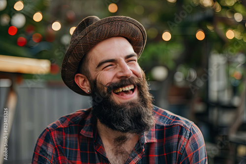 Laughing man with stylish long hipster beard in candid moment photo