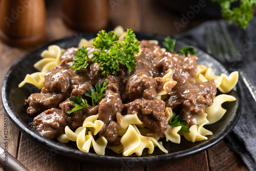 Beef stroganoff with egg noodles garnished with parsley