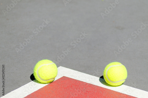 two tennis balls on a tennis court line