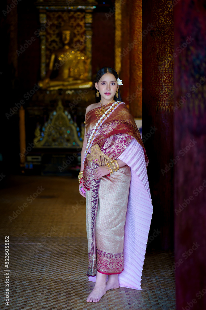 Fototapeta premium Pretty Asian women in traditional Thai dress. Beautiful traditional Thai dresses by Asian Buddhists make merit at the Temple a tourist attraction, a famous place in Thailand.