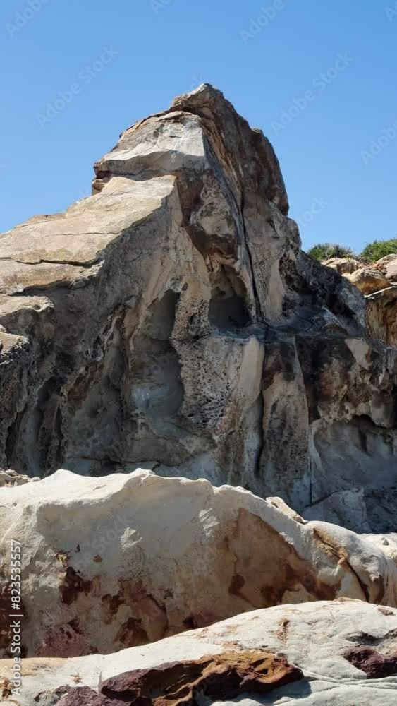 Detailed view of a rugged and textured rock face against a bright blue sky Detailed view of a rugged and textured rock face against a bright blue sky