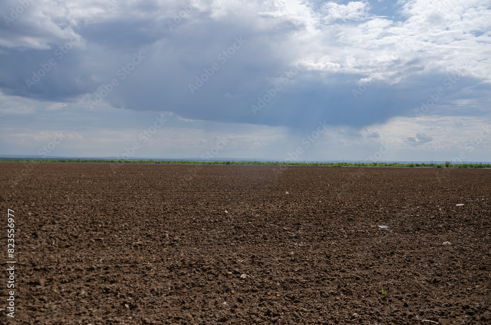 A ploughed field for planting, a dark sky with light gaps. minimalism A ploughed field for planting, a dark sky with light gaps. minimalism