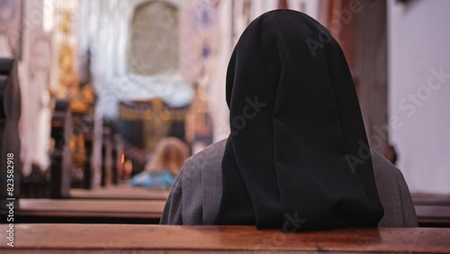 Catholic Nun Wearing Grey Religious Habit Tunic Saying Prayer During Holy Mass photo