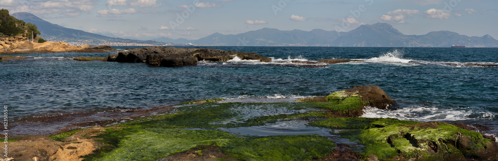 panorama di Marechiaro a Napoli con veduta del Vesuvio e isole campane con onde e rocce in primo piano