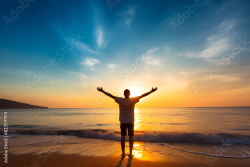 Happy man raising arms up enjoying sunset on the beach - Delightful traveler standing with hands up looking morning sunrise - Self care, traveling, wellness and healthy life style concept