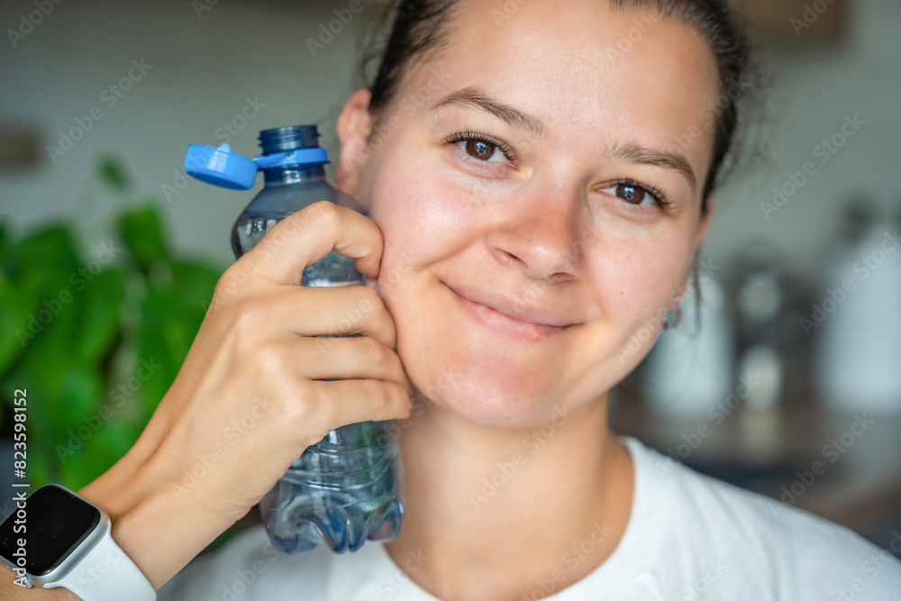 Young woman with bottle with stationary plastic cap. The new design means the cap remains attached to the bottle after opening, making the entire package easier to collect and recycle Young woman with bottle with stationary plastic cap. The new design means the cap remains attached to the bottle after opening, making the entire package easier to collect and recycle