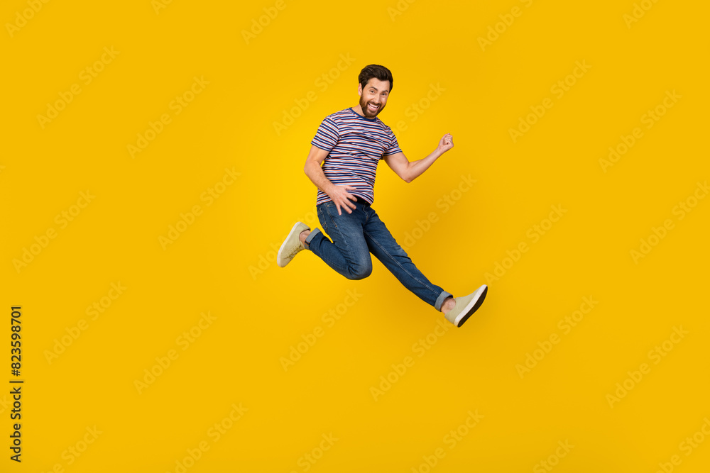 Full length body photo of young adult bearded man jumping and loves playing guitar in air isolated over yellow color background
