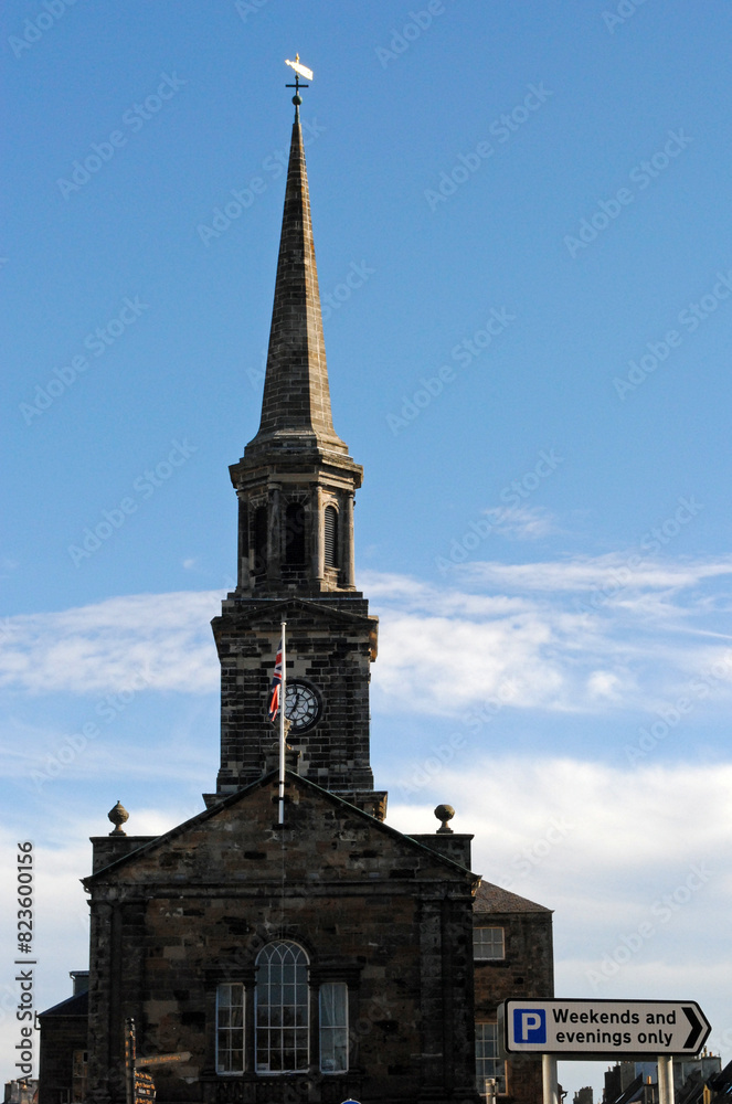 Old Church with Spire and Clock seen against Blue Sky Old Church with Spire and Clock seen against Blue Sky