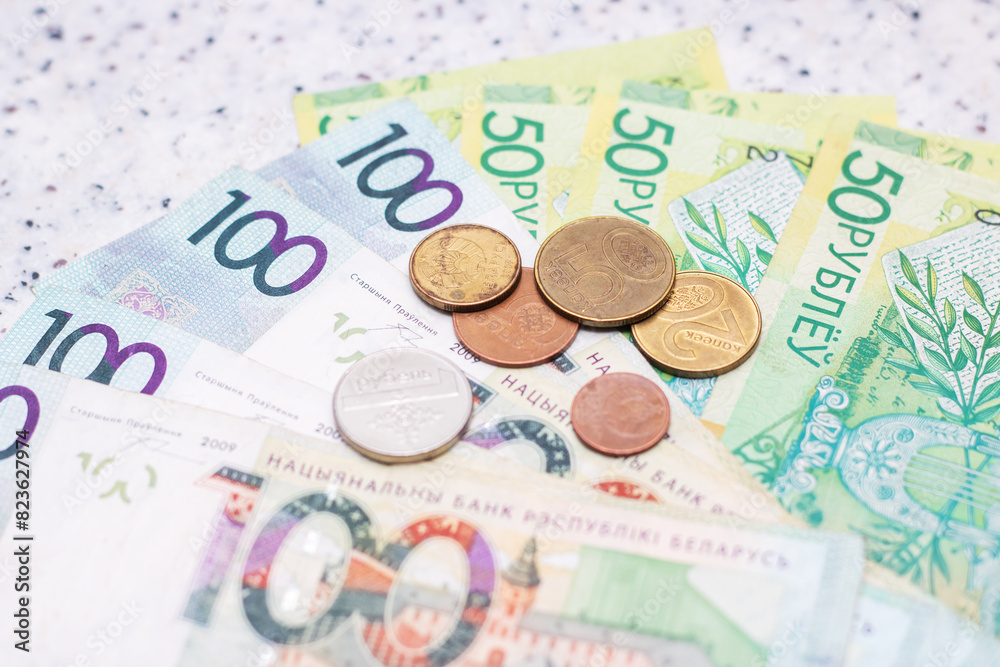 Saving money handling a stack of green banknotes and pink coins on a table Saving money handling a stack of green banknotes and pink coins on a table