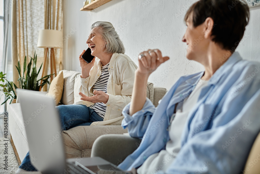 Two women chatting on phone while relaxing on couch. Two women chatting on phone while relaxing on couch.