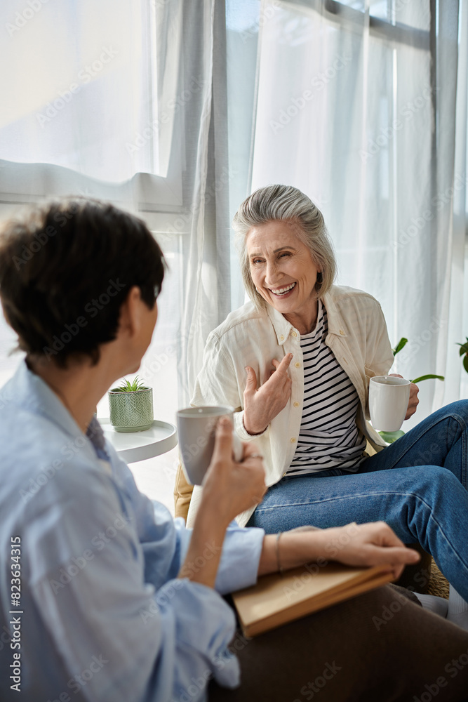 Obraz premium Two women deep in conversation, enjoying coffee together in a cozy room.