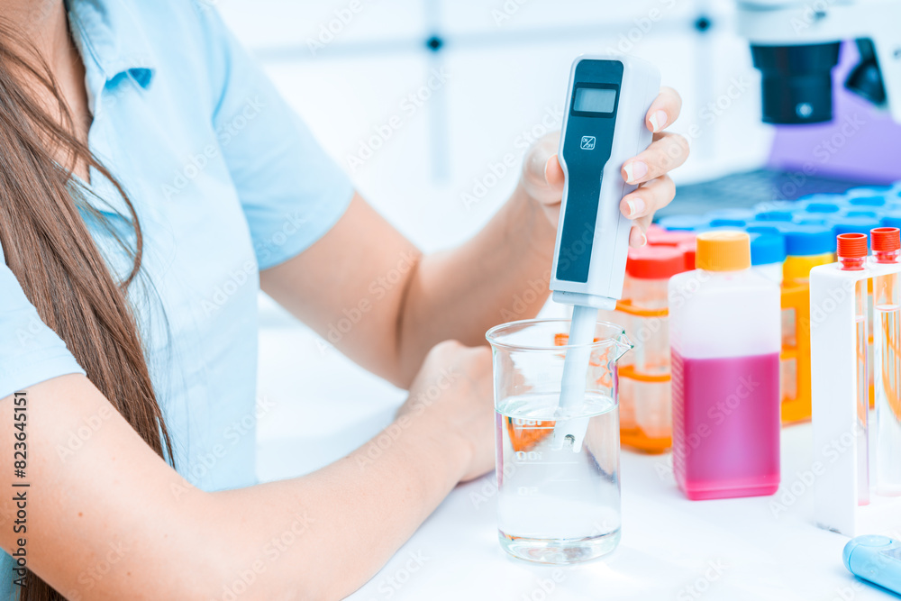 Fototapeta premium female laboratory assistant in the laboratory examines river water samples for harmful substances and pathogens