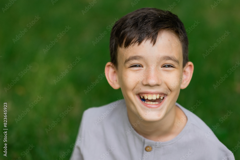 Portrait of a little boy on a green lawn laughing, looking at the camera, Portrait of a little boy on a green lawn laughing, looking at the camera,